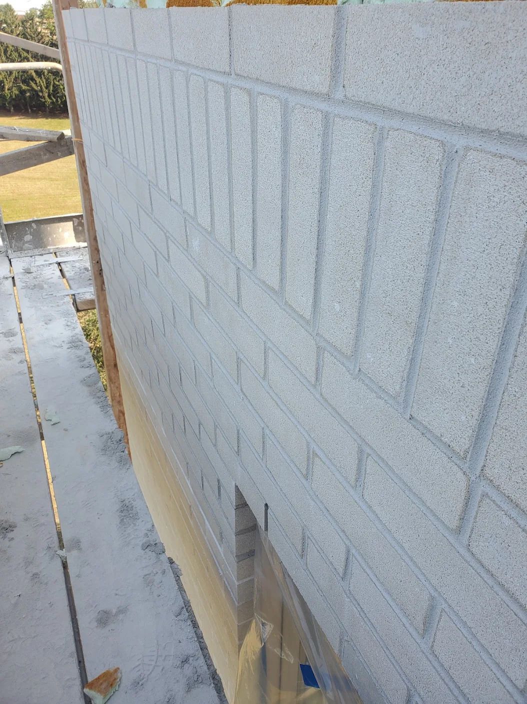 Un mur de briques est peint en blanc avec un pinceau.