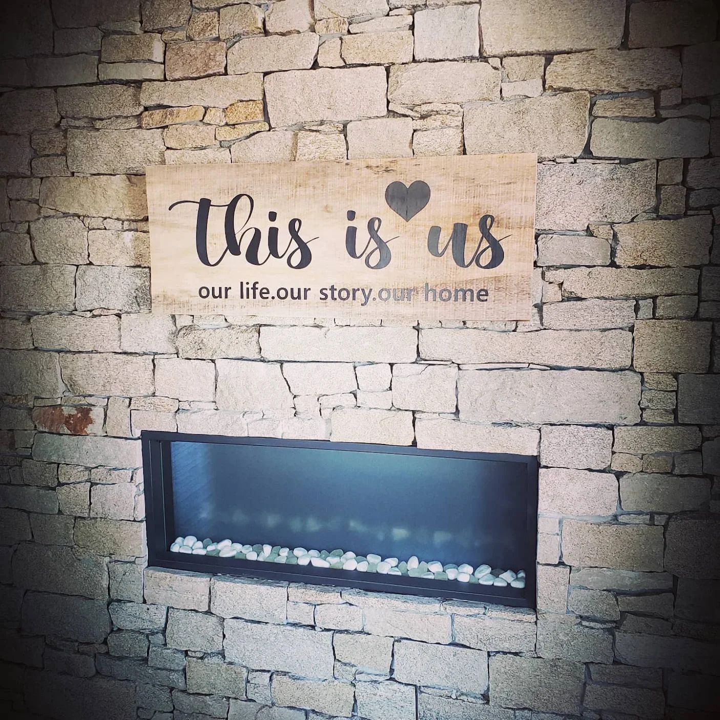 Un panneau sur un mur de briques dit ceci est nous notre vie notre histoire notre maison