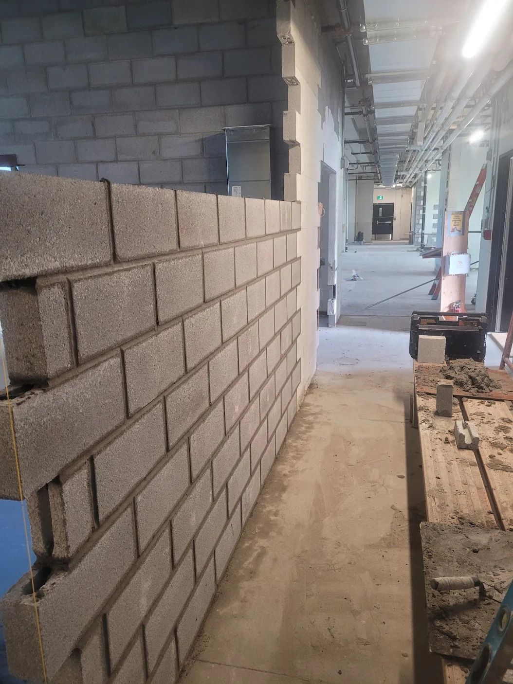 Un mur de briques est en train d'être construit dans un bâtiment.