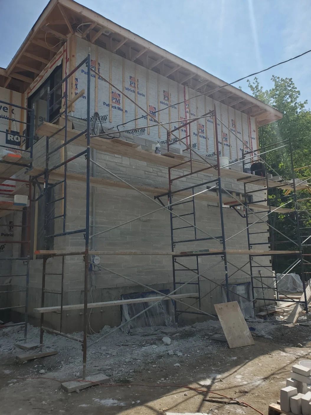 Une maison est en construction avec des échafaudages autour.