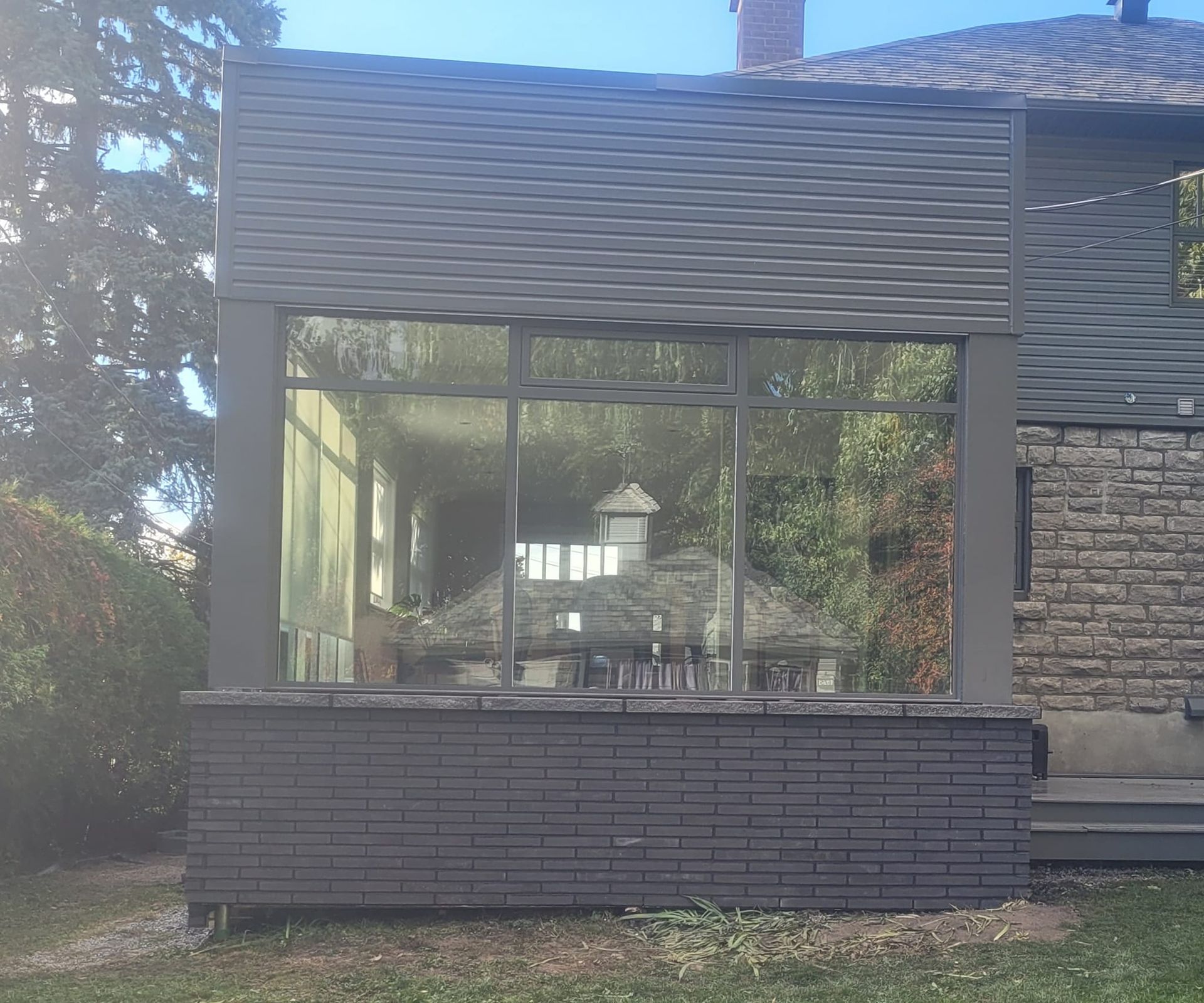 Une maison avec une grande fenêtre sur le côté