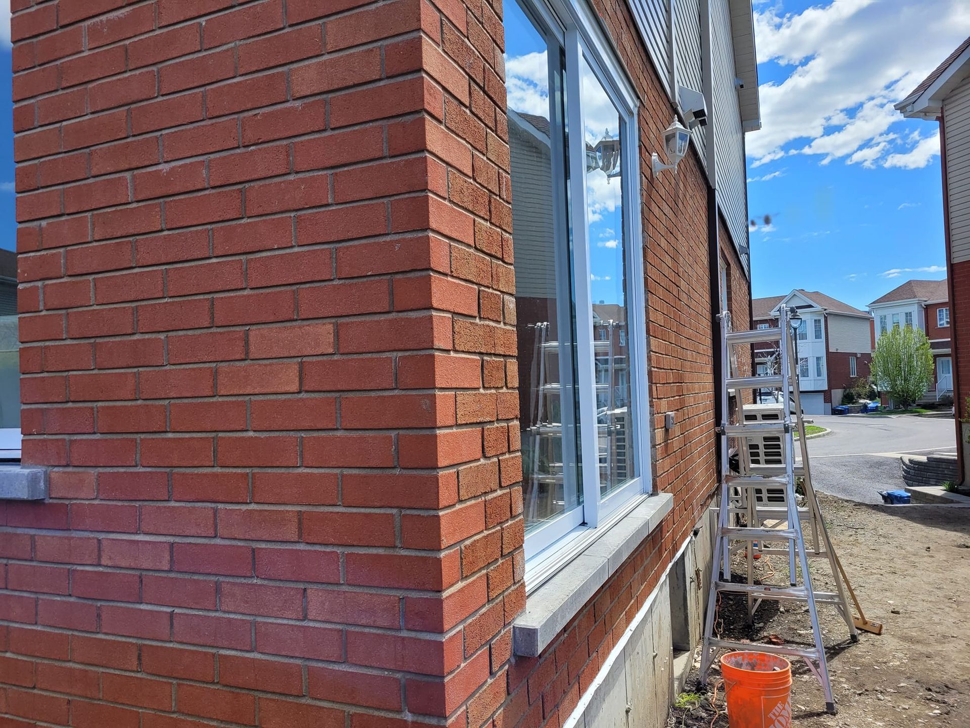 Un bâtiment en briques avec une fenêtre et une échelle devant.