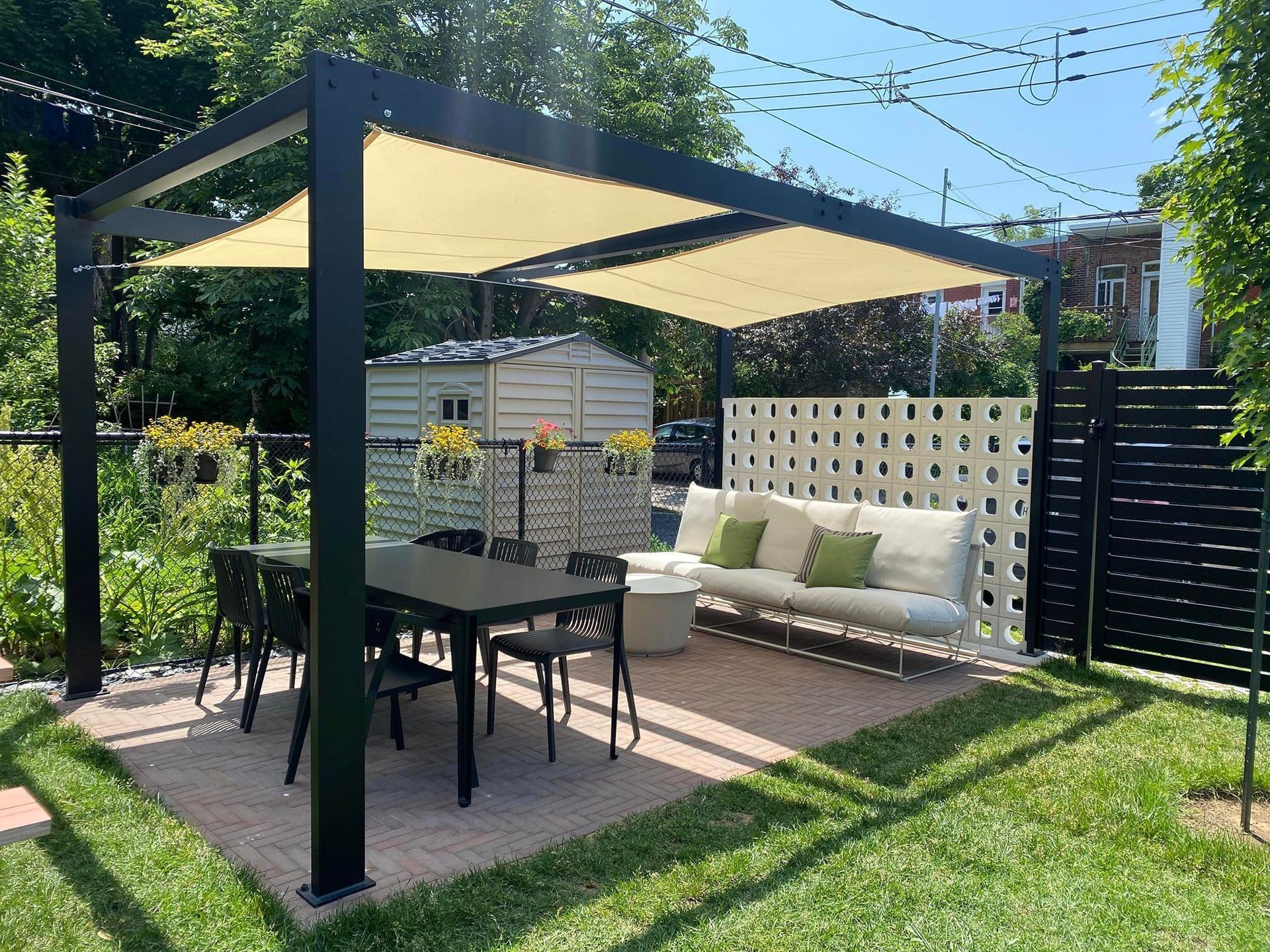 Il y a une table et des chaises sous un auvent dans l'arrière-cour.