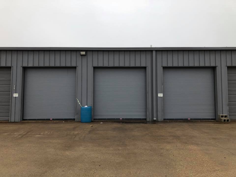 Commercial Garage Door - A Front View Of Three Closed Ribbed Garage Doors in Dallas/Fort Worth, TX