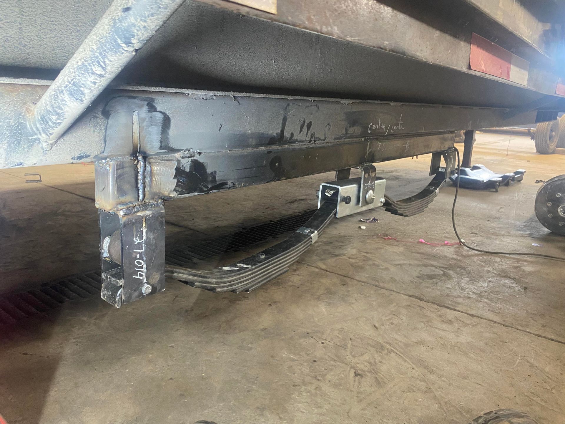 A trailer is sitting on the ground in a garage.