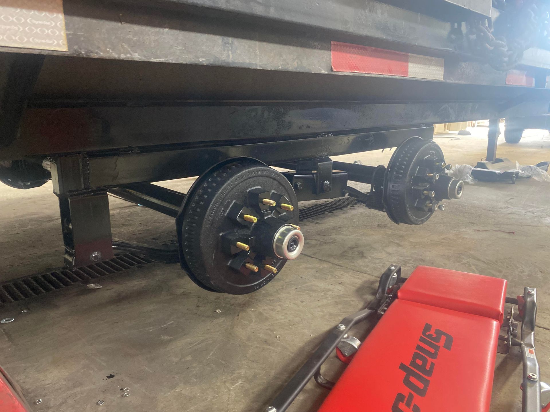 A trailer is being lifted by a snap on jack.
