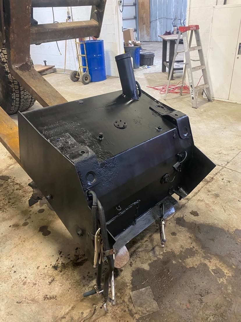 A black box is sitting on the floor in a garage.