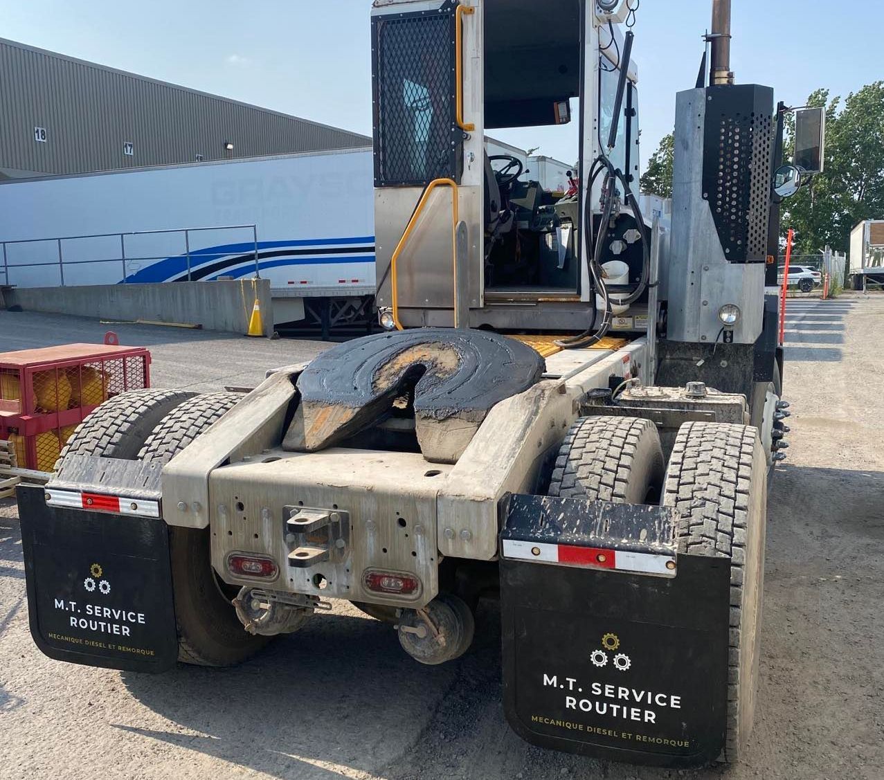 Un semi-remorque Mi Service Routier est stationné dans un parking
