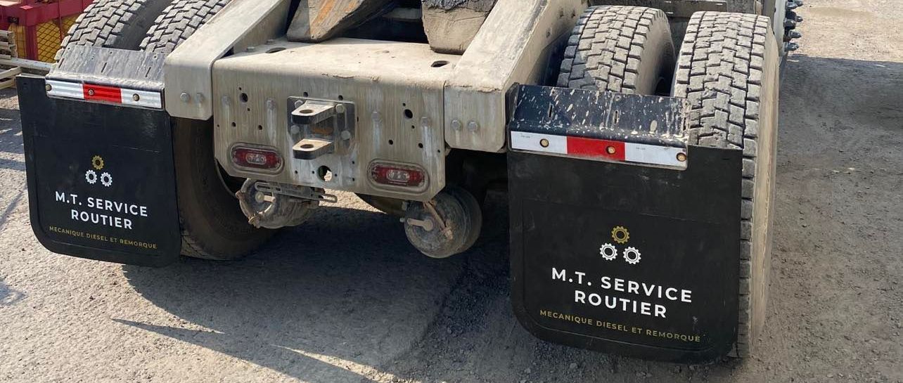 L'arrière d'un semi-remorque avec des garde-boue dessus.