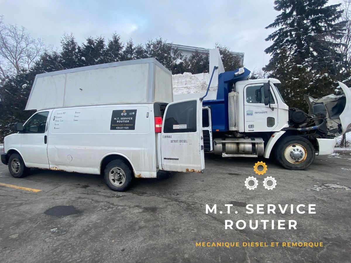 A white van is parked next to a blue truck in a parking lot.