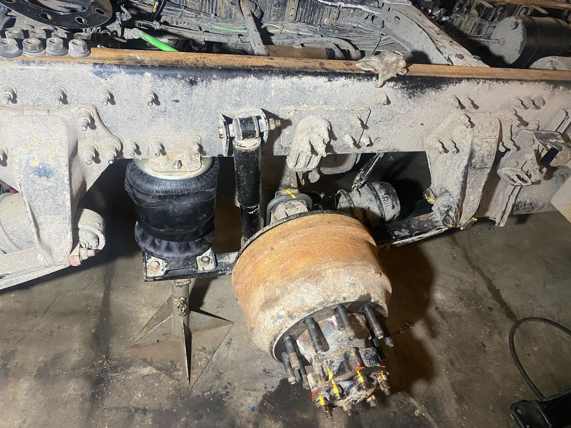 A close up of a truck 's suspension system sitting on the ground.