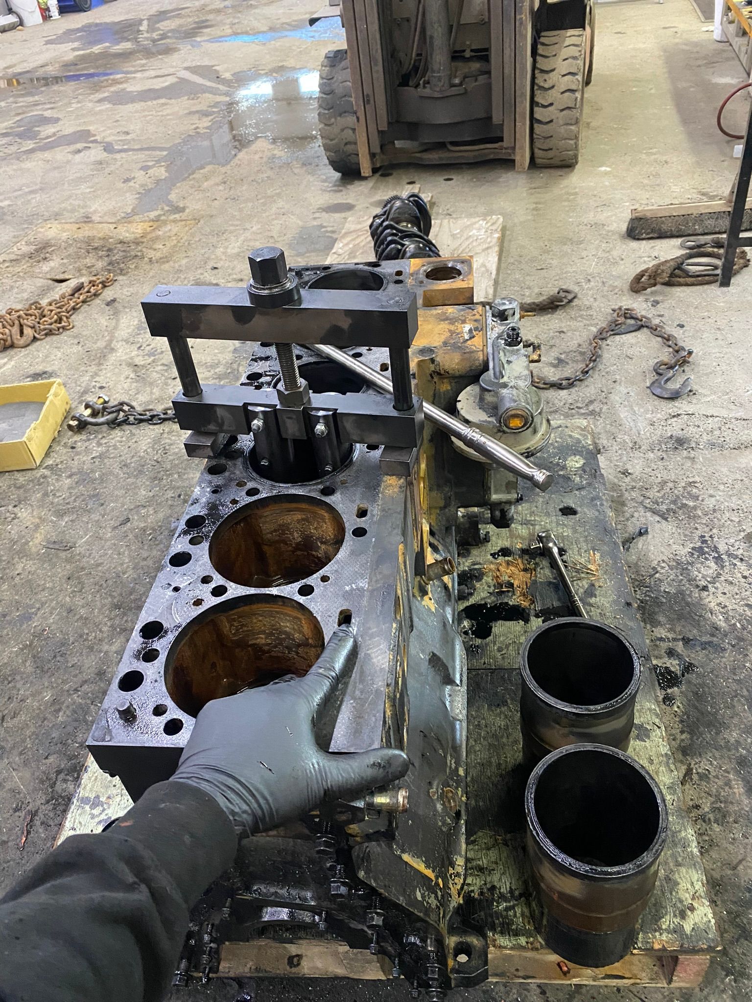 A person is working on a cylinder block in a garage.