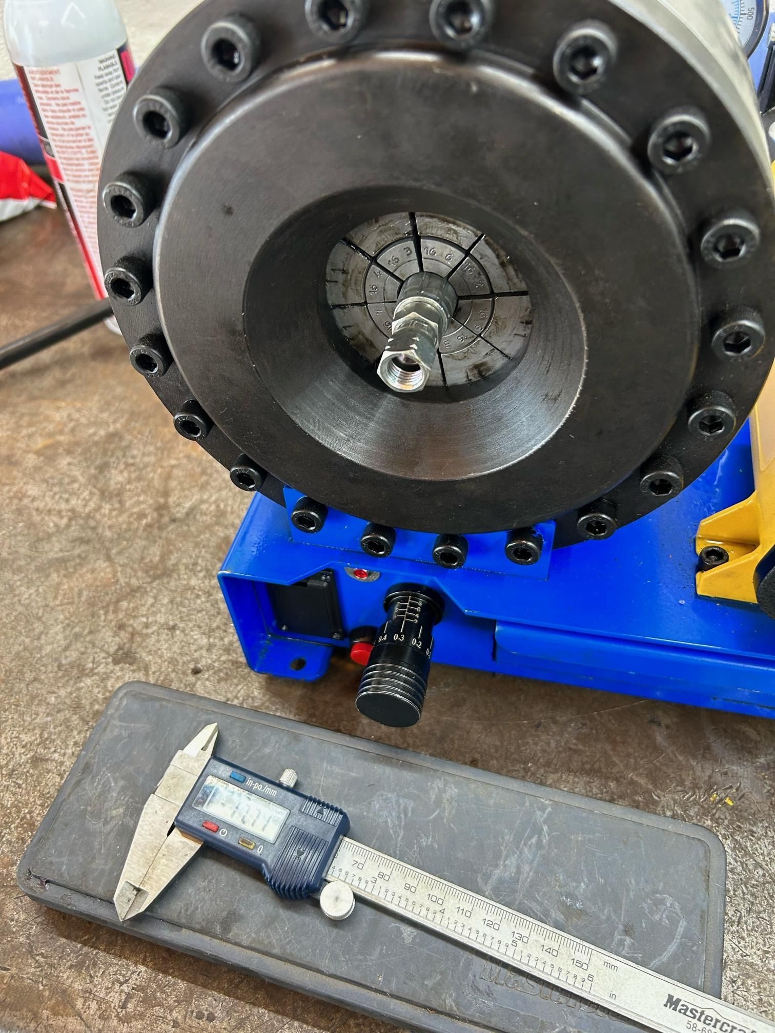 Un pied à coulisse est posé à côté d'une machine sur une table.