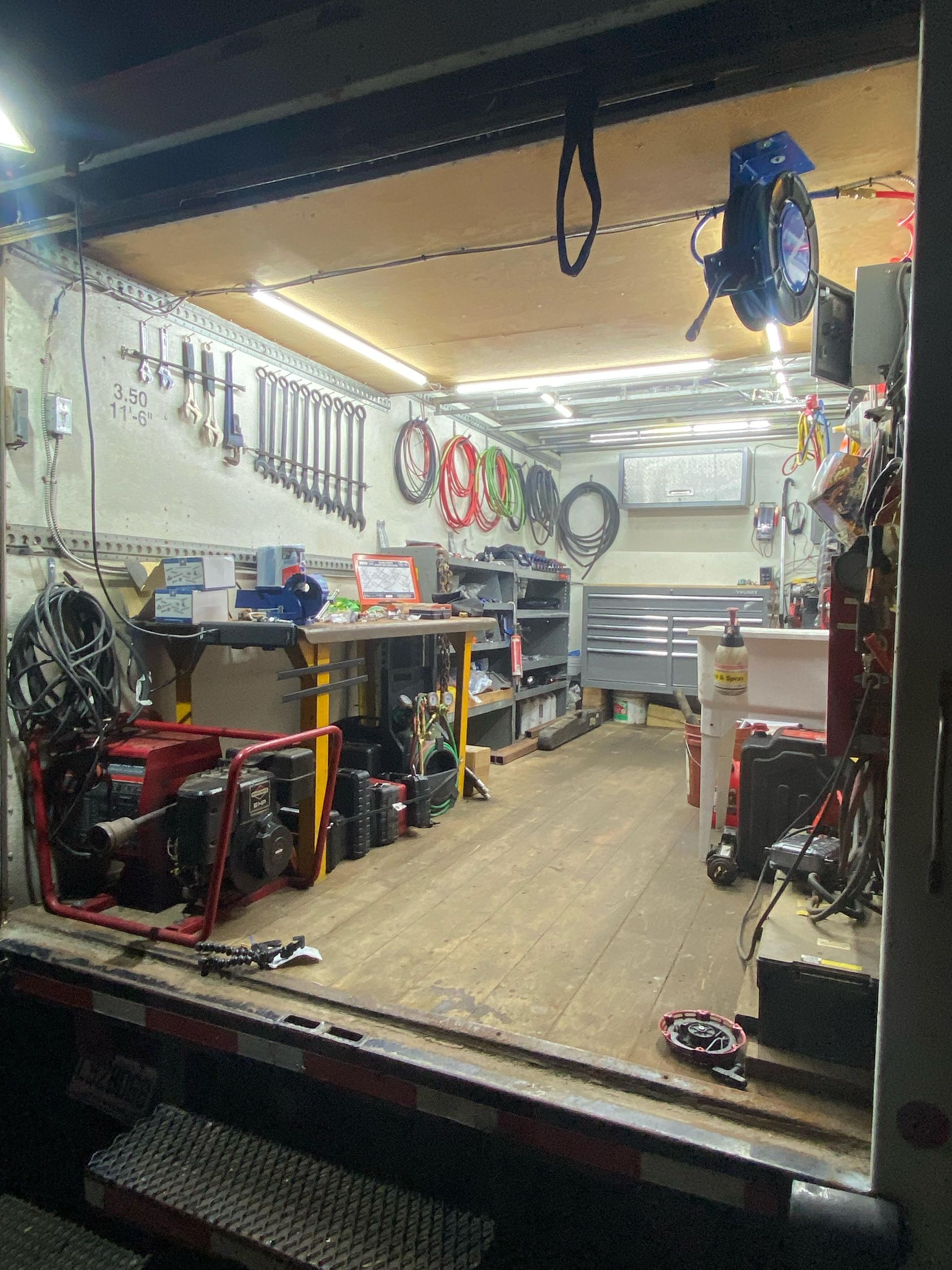 The inside of a garage with a lot of tools on the wall.