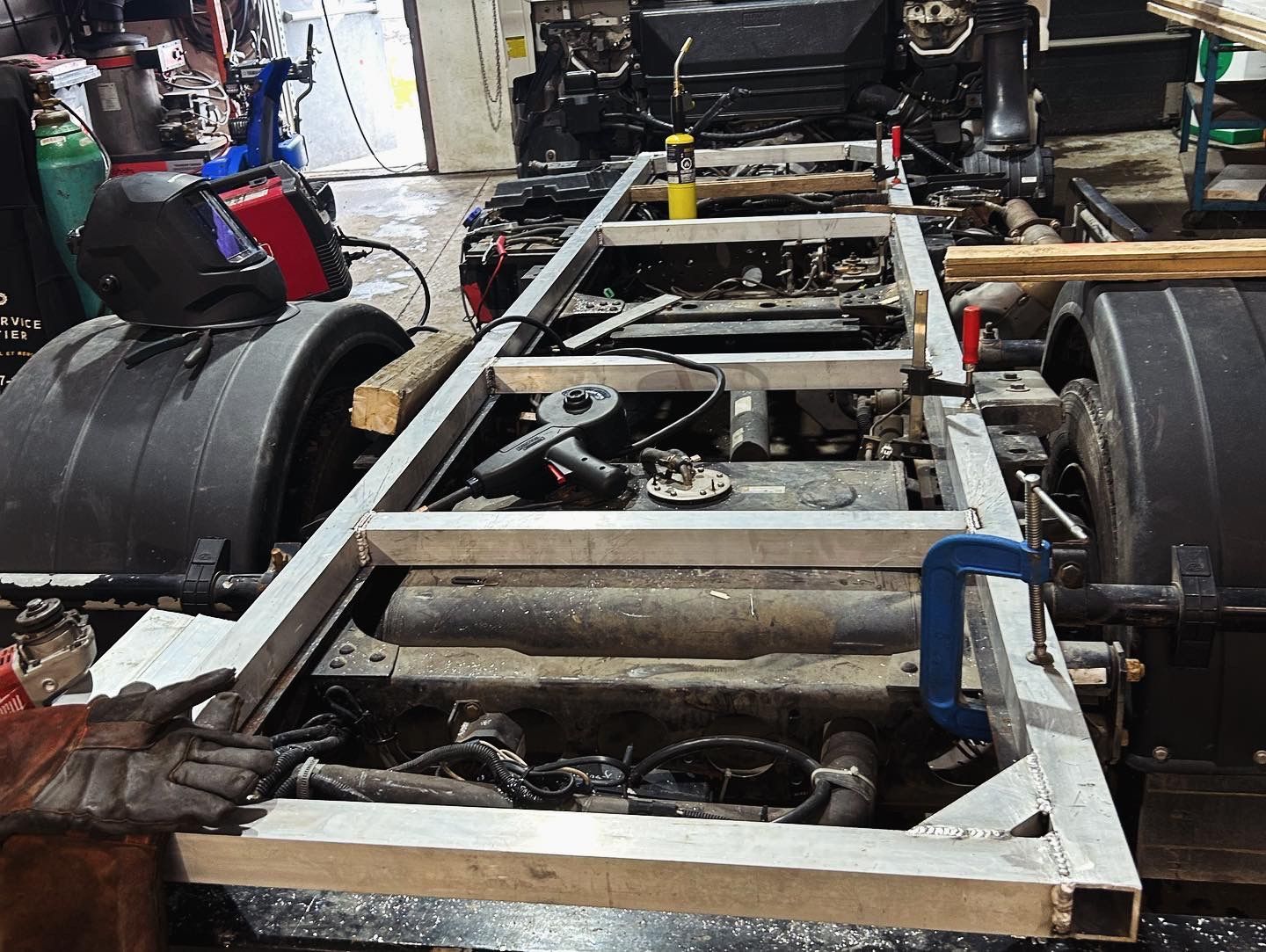 A truck frame is being built in a garage