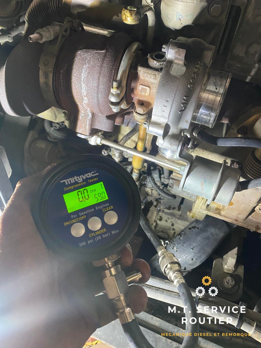 A person is holding a digital gauge in front of a turbocharger.