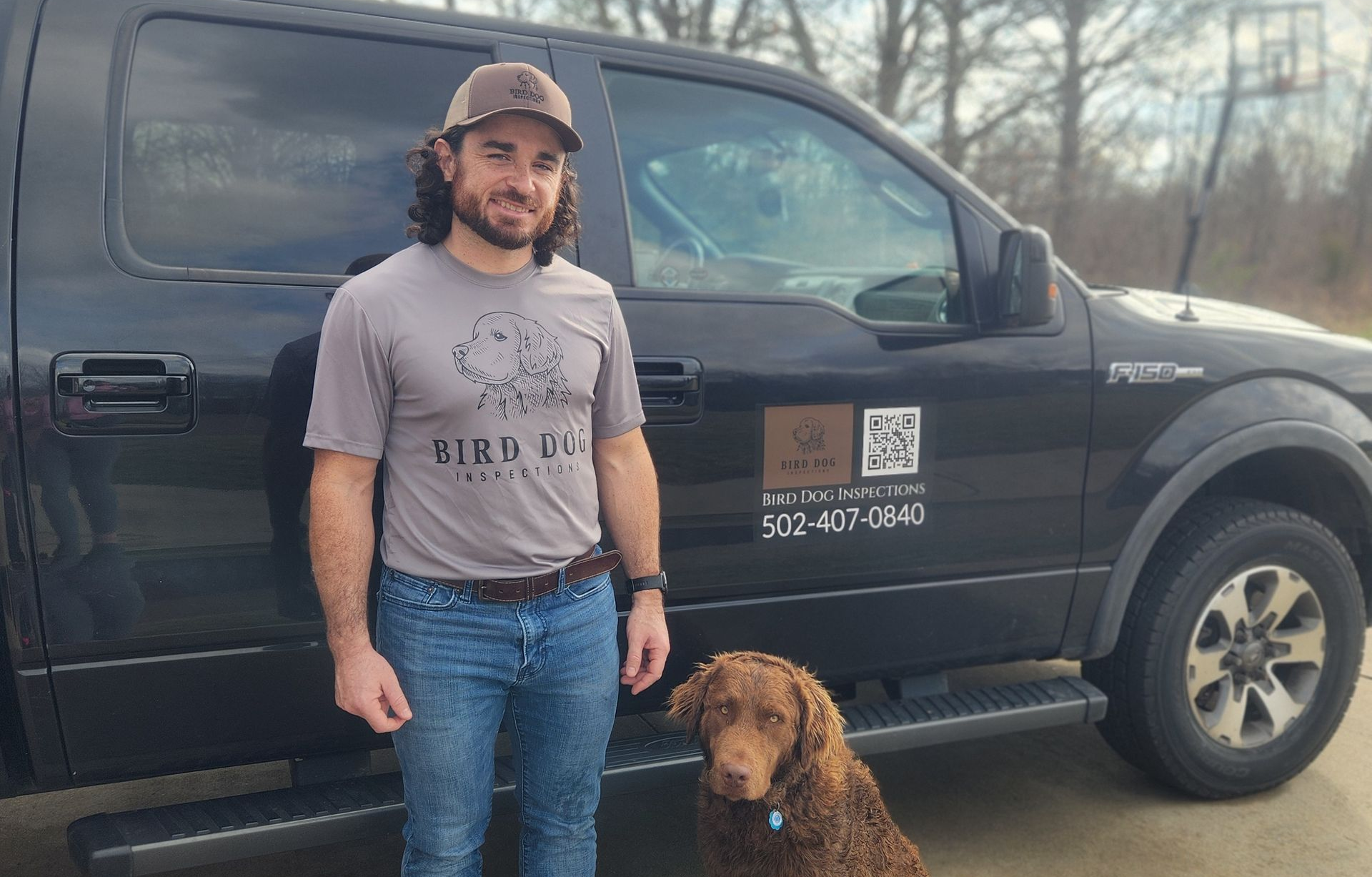 Small, modern house with black trim, light siding, and dark door; for sale sign out front.