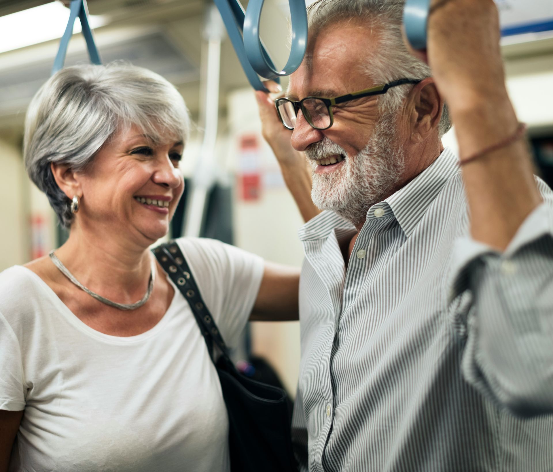 A man and a woman are riding a train together.