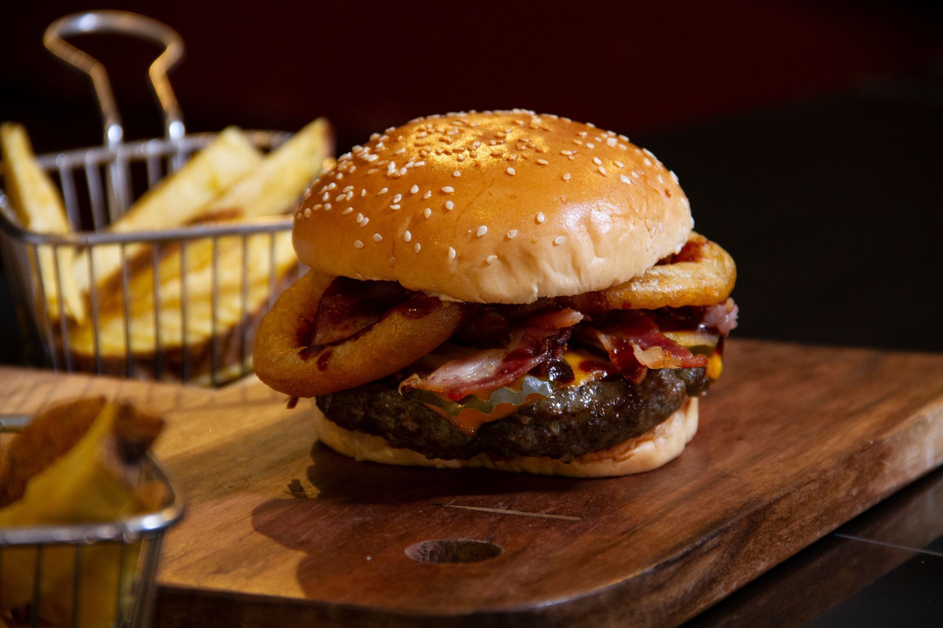 Hamburger with onion rings, melted cheese and meat.