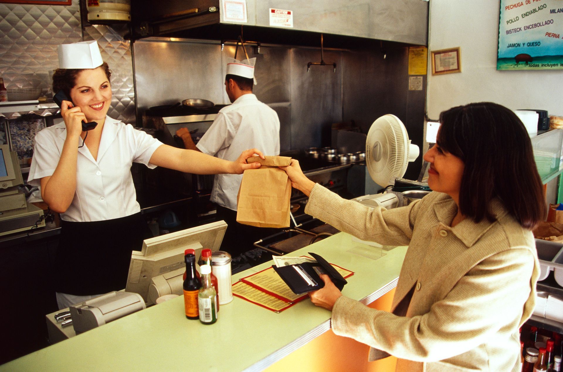 A person handing over a bag to a waitress