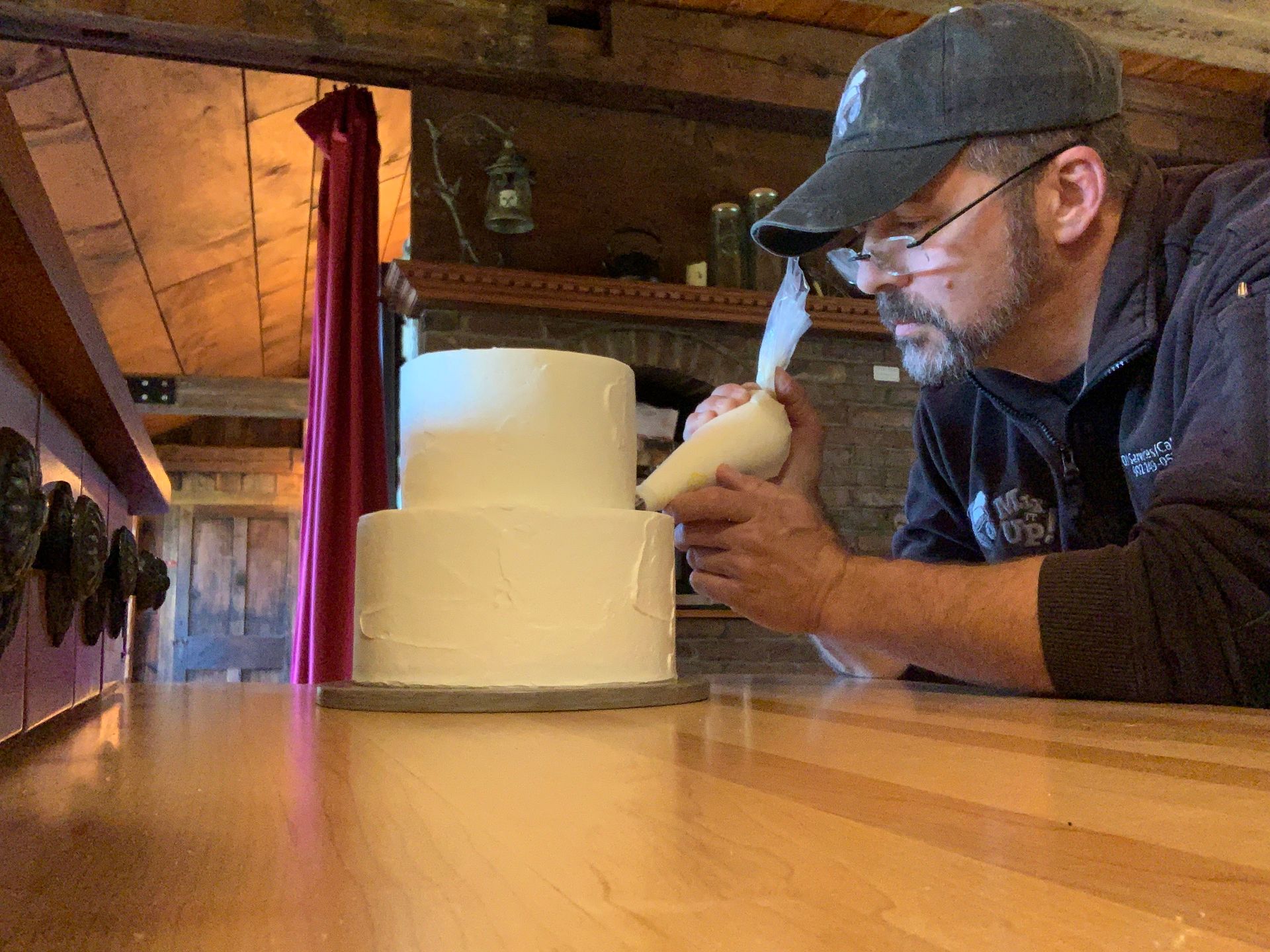 DJ Rousseau applying finishes touches to a wedding cake at Ted Williams home.