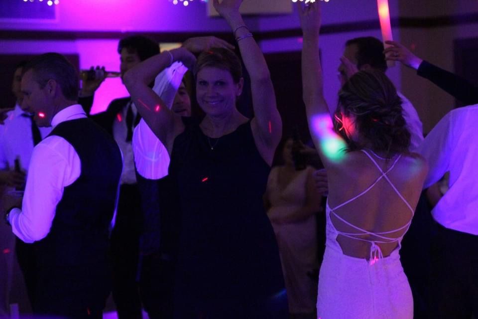 Mix It Up! providing dj services to a wedding where a group of people are dancing with glow sticks