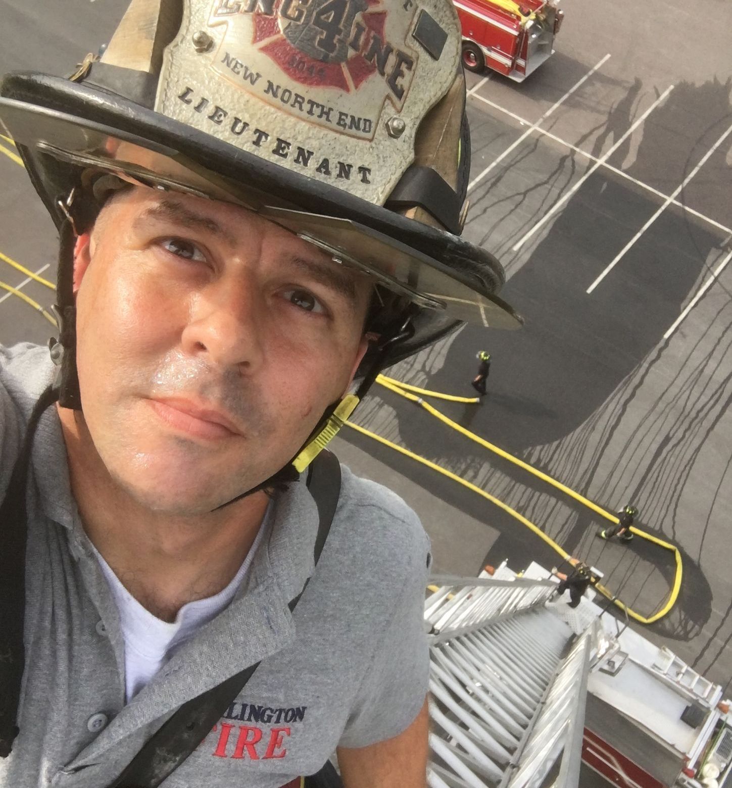 Lt DJ Rousseau atop Burlington Fire Dept Ladder 4 looking down from 70-feet up.