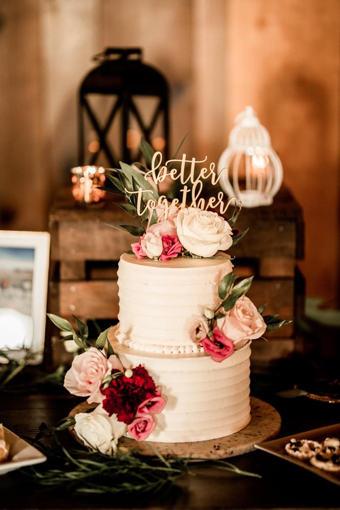 Mix It Up! custom wedding cakes 2 tier cake with white frosting with many shades of pink flowers on it