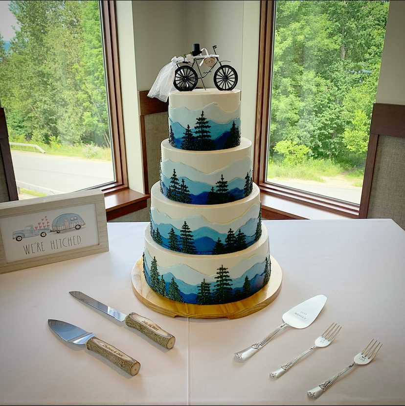 Mix It Up! custom wedding cakes 4 tier cake with white frosting with mountain and trees scenery