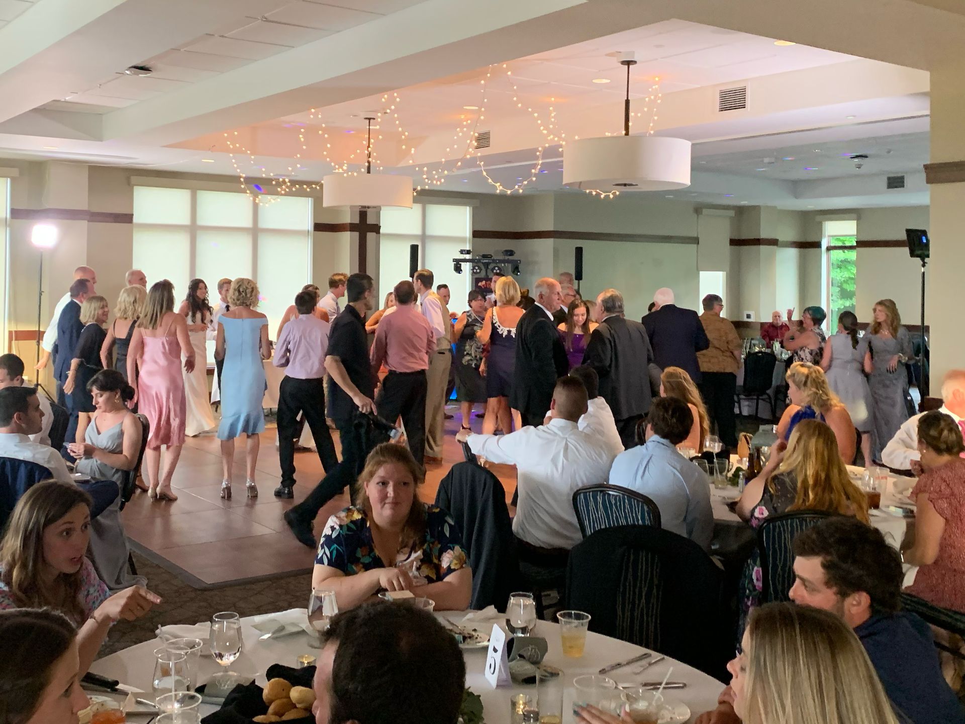 Mix It Up! providing dj services for a wedding, with a large group of people are dancing and a few people sitting at tables watching