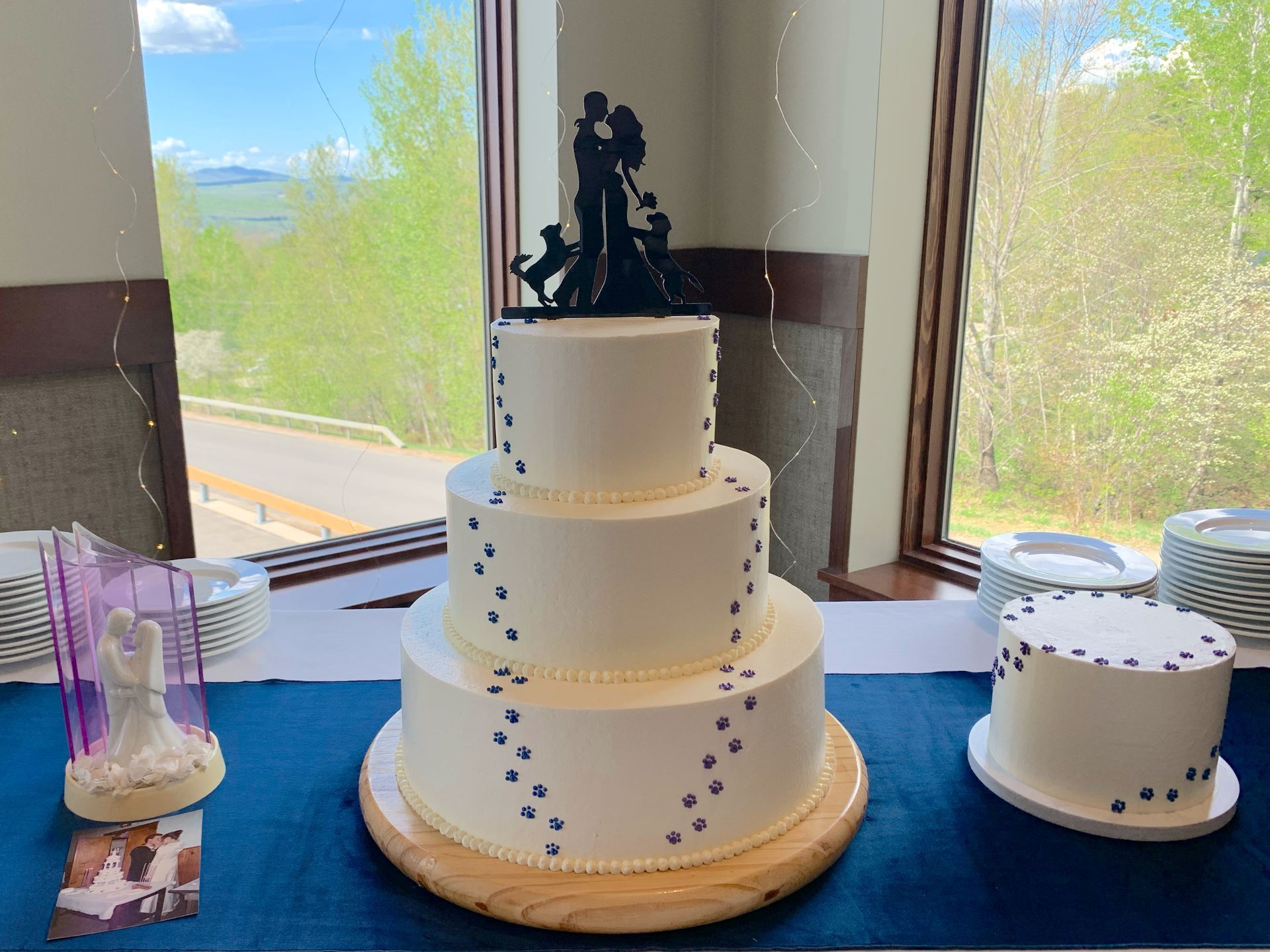Mix It Up! custom wedding cakes 3 tier white frosting with blue footprints leading to the cake topper