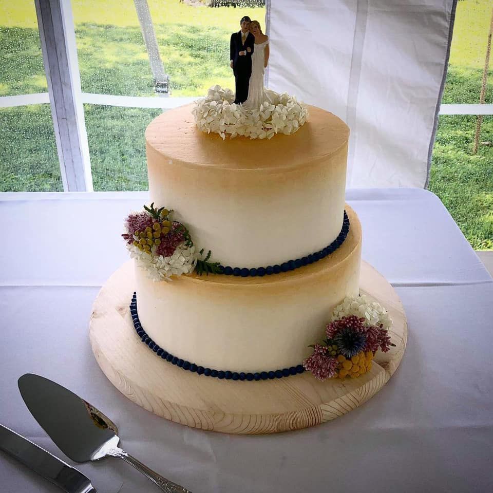 Mix It Up! custom wedding cakes 2 tier cake with white and light brown frosting with brown and white flowers flowers on it