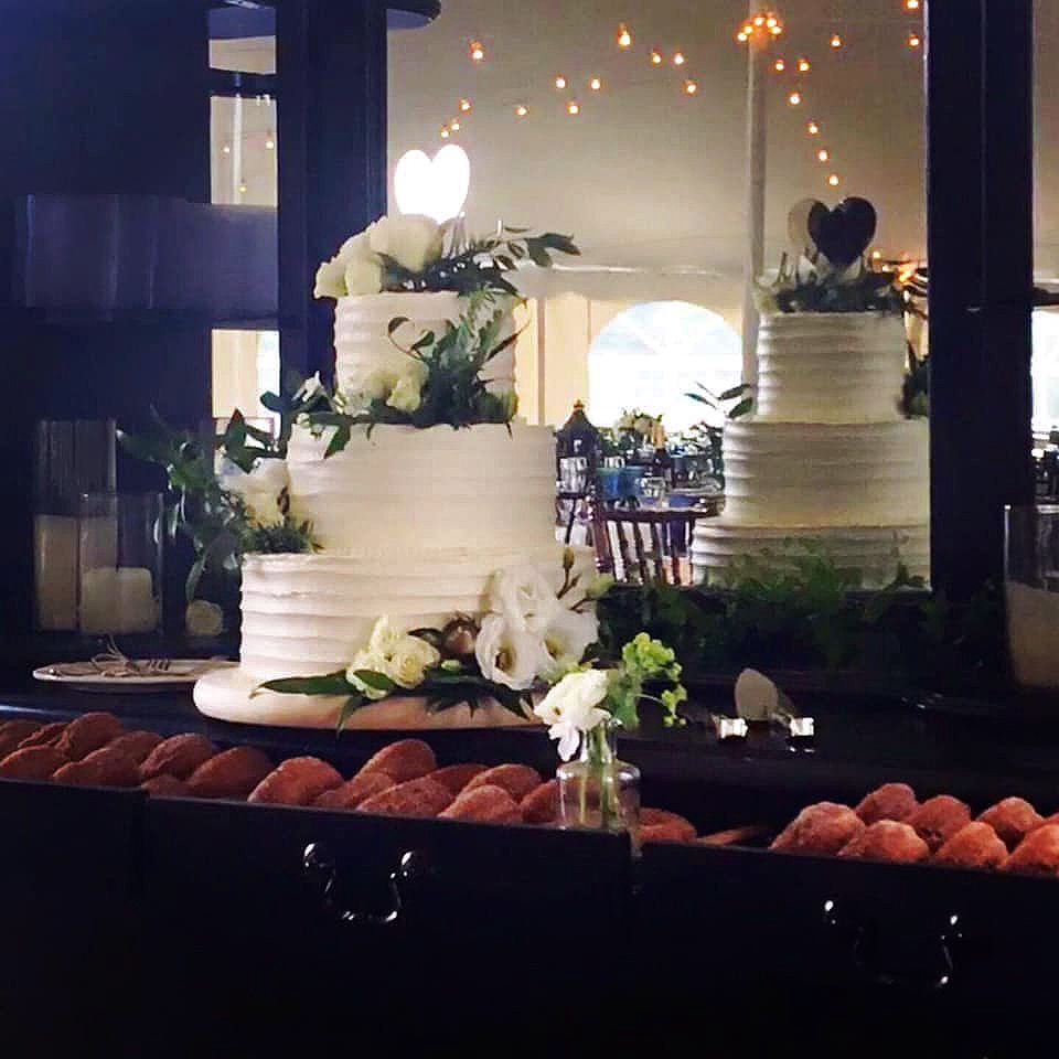 Mix It Up! custom wedding cakes 3 tier white frosting with lots of flowers on and around the cake