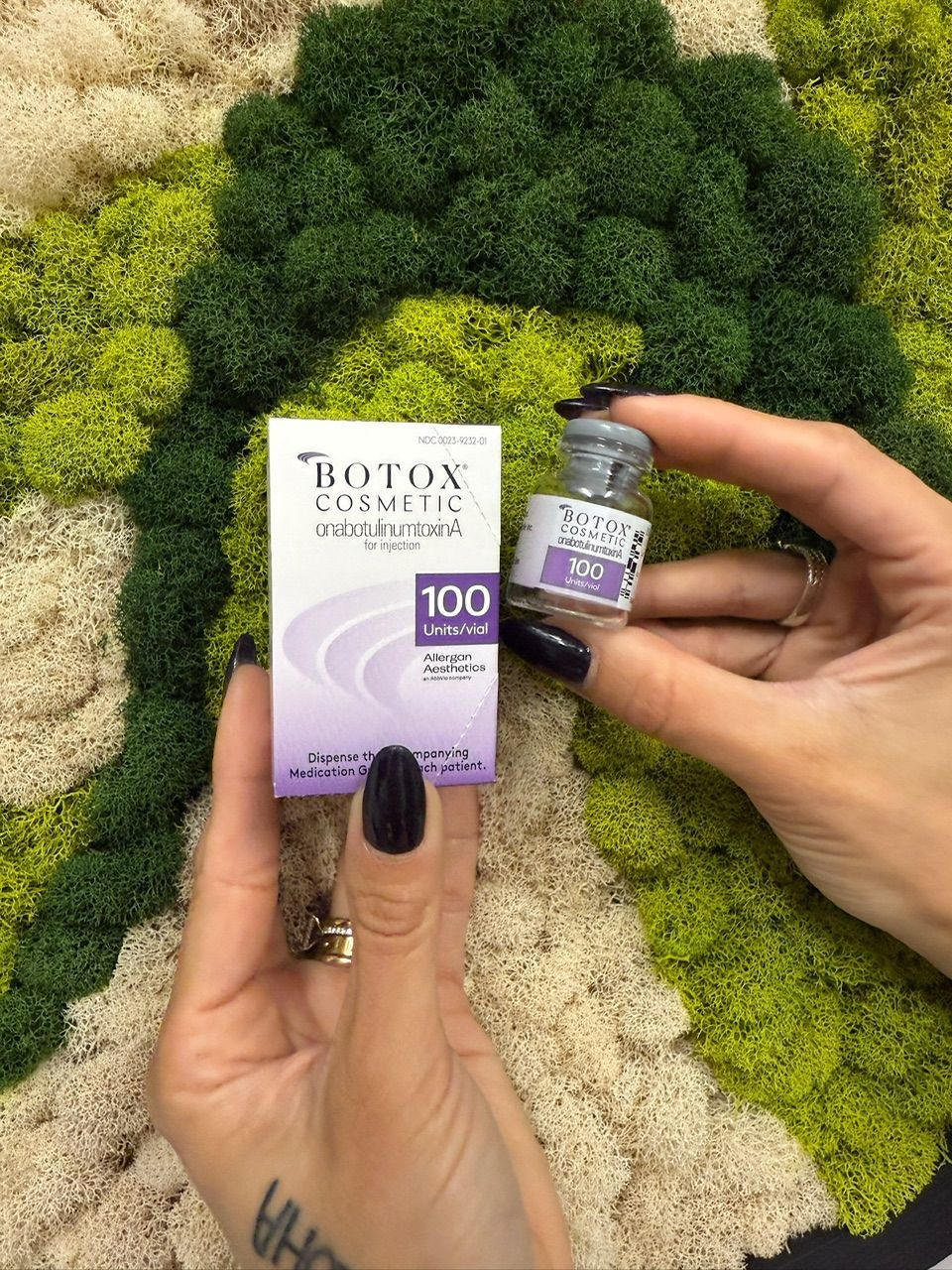 A woman is getting a botox injection in her forehead.