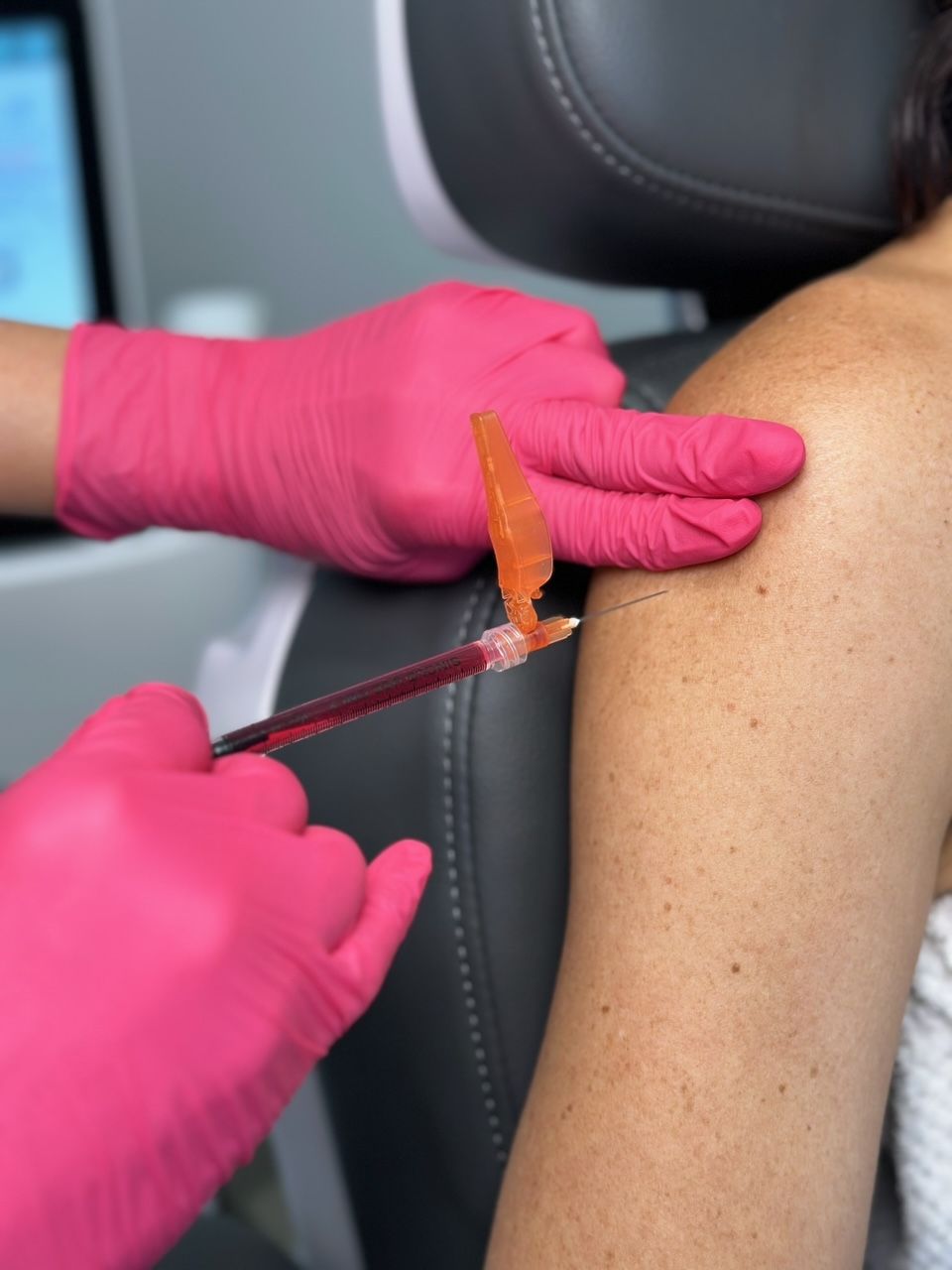 A woman is sitting in a chair with an iv in her arm.