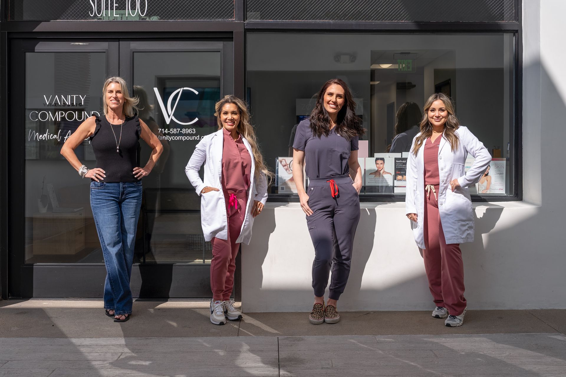 A group of women in scrubs are standing in front of a building.