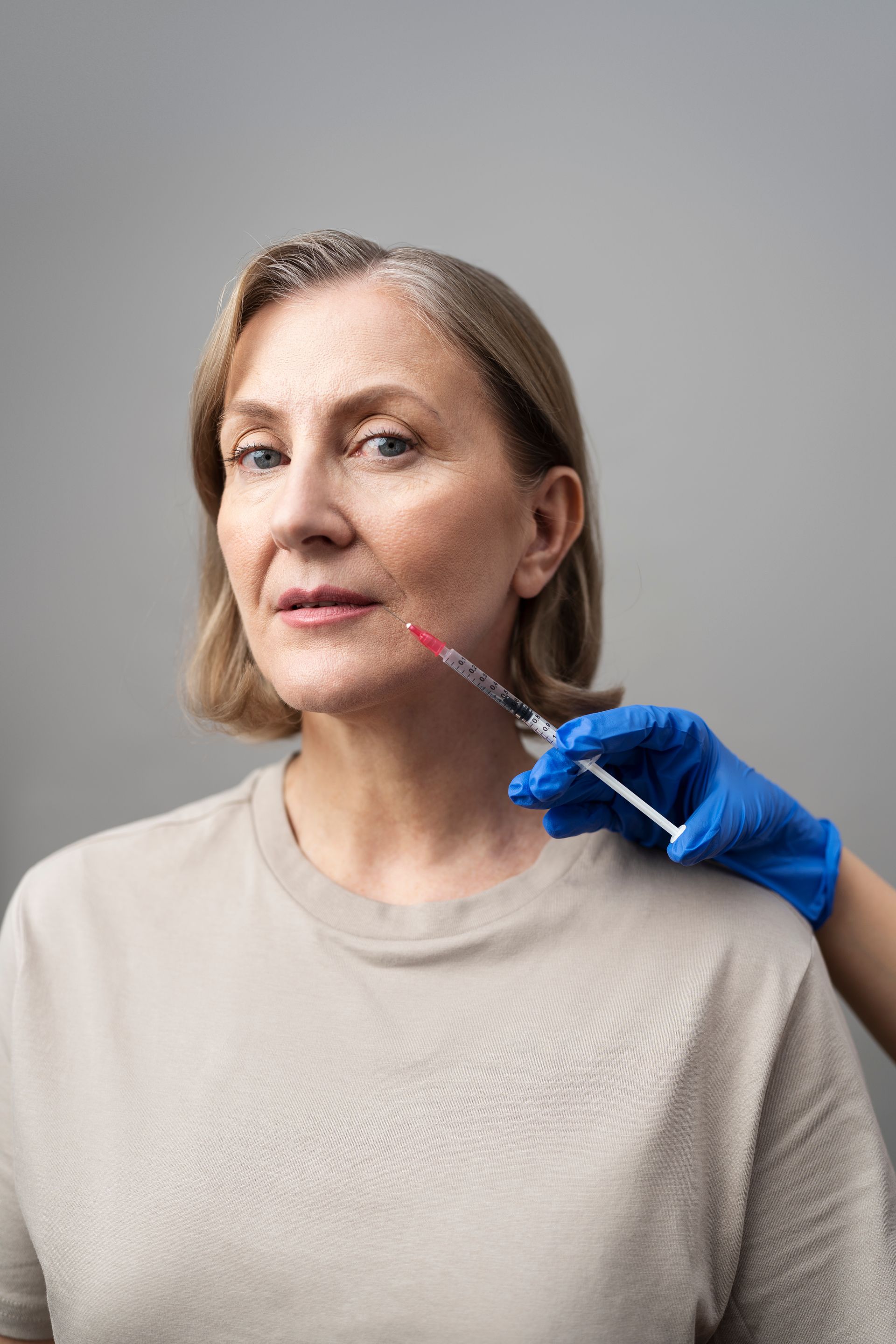 A woman is getting a botox injection in her face.