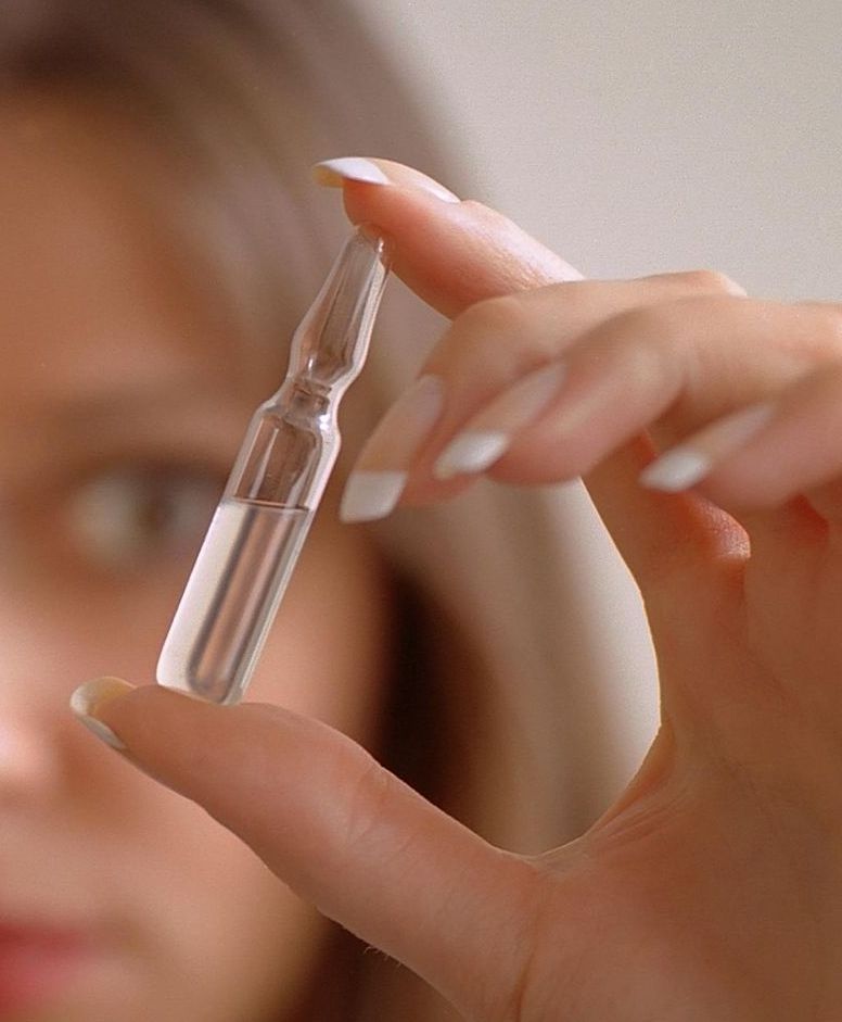 A doctor is holding a syringe and a bottle of vaccine.