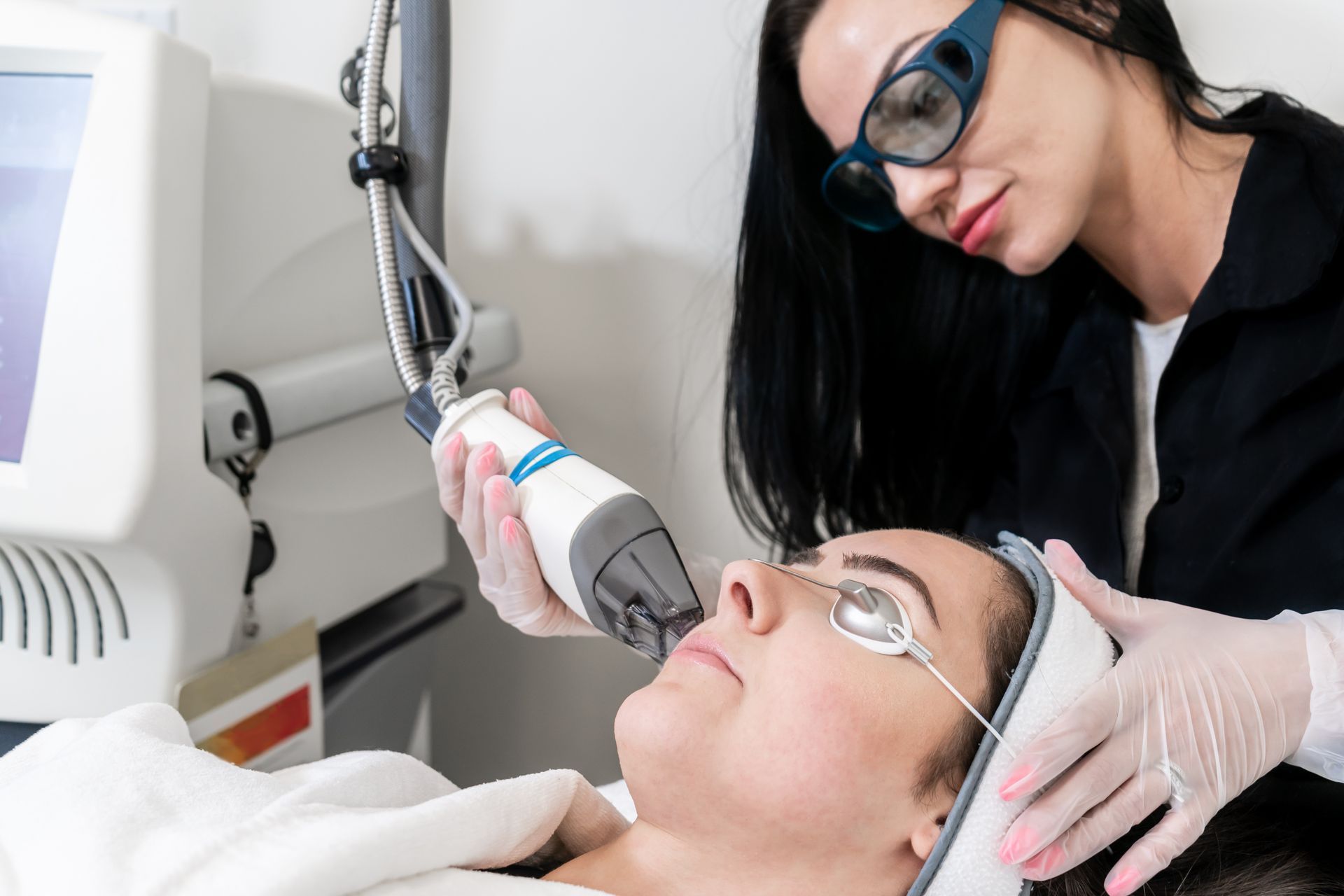 A woman is getting a laser treatment on her face.