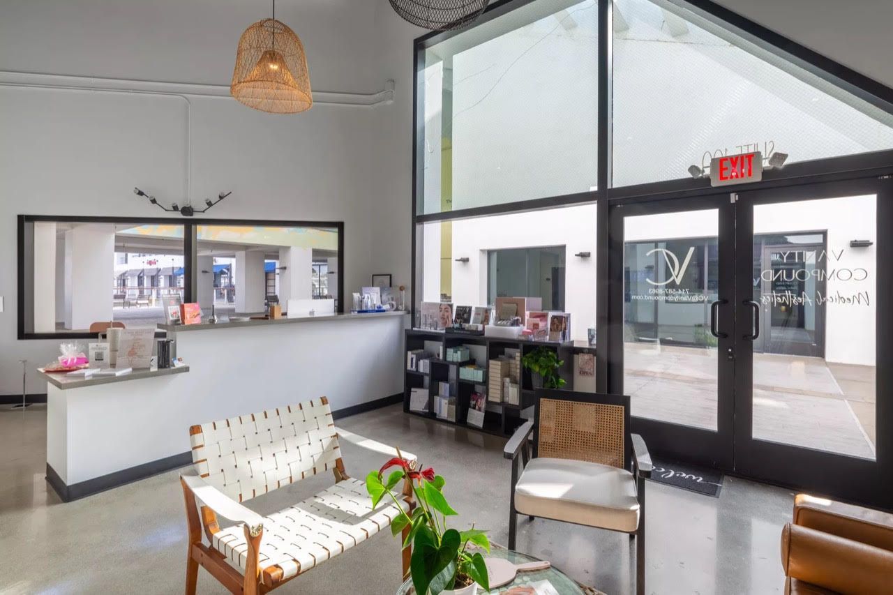 A lobby with a couch , chairs , and a large window.