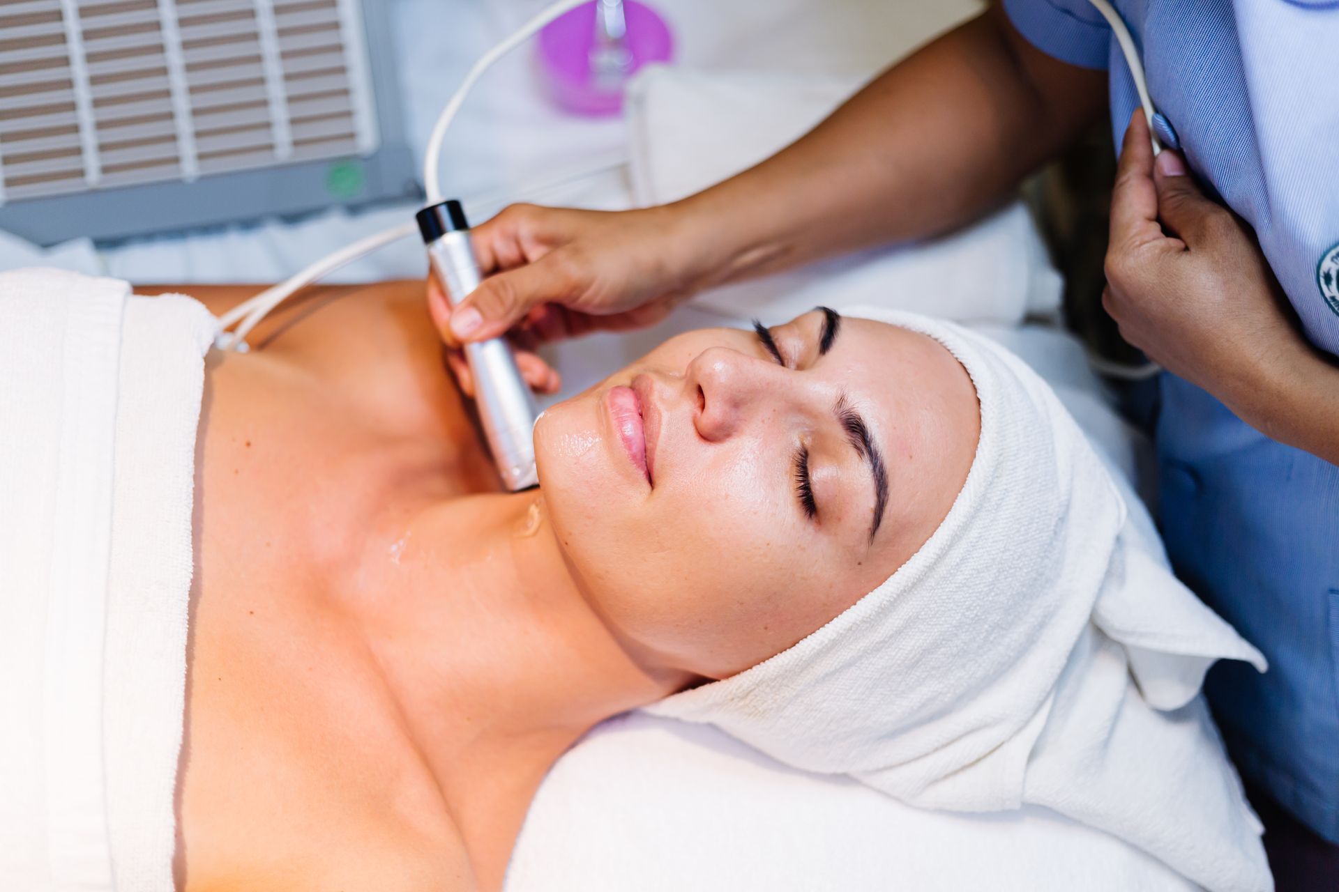 A woman is getting a tempsure envi  treatment at a spa.