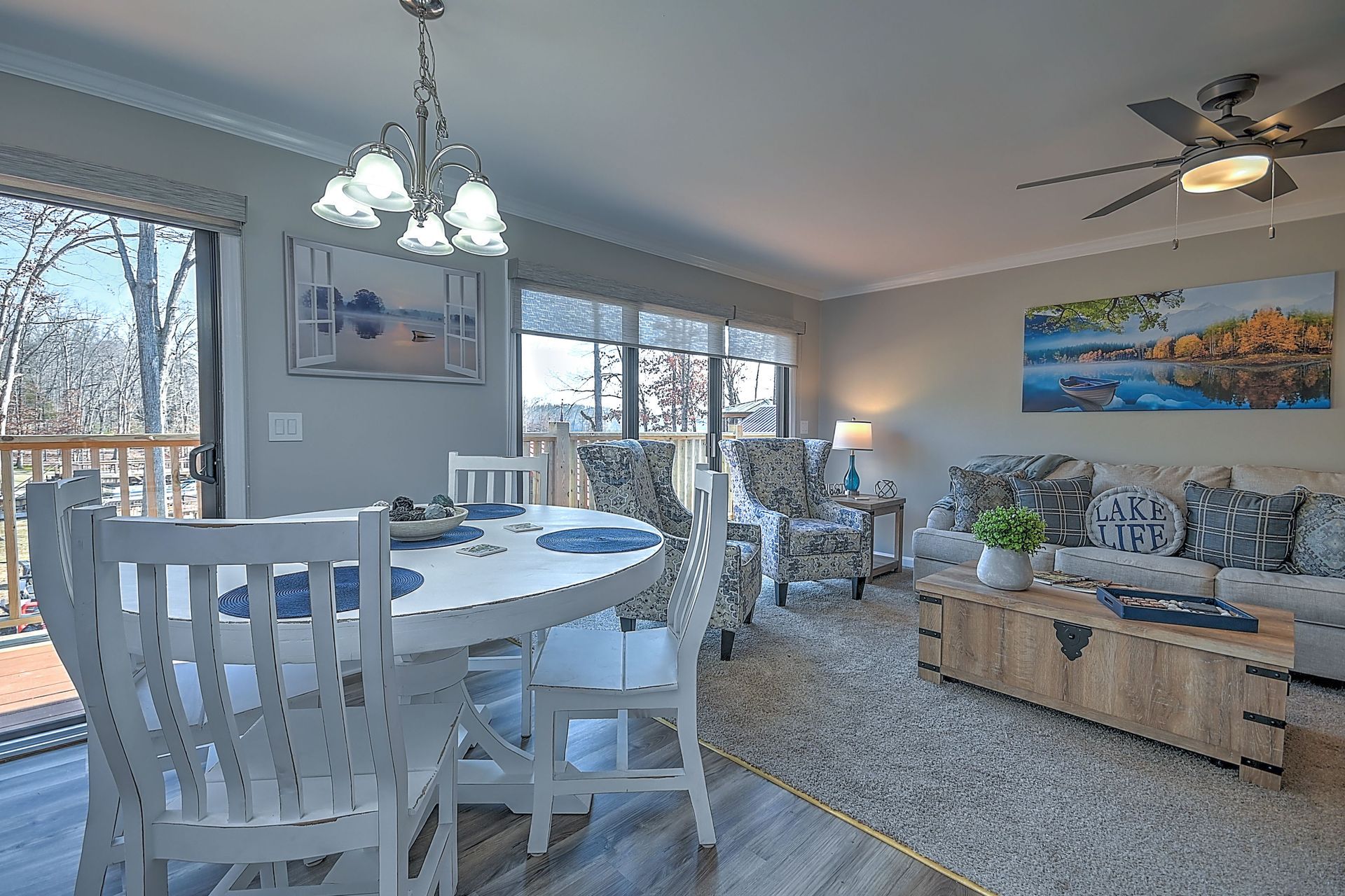 A living room with a dining table and chairs and a ceiling fan.