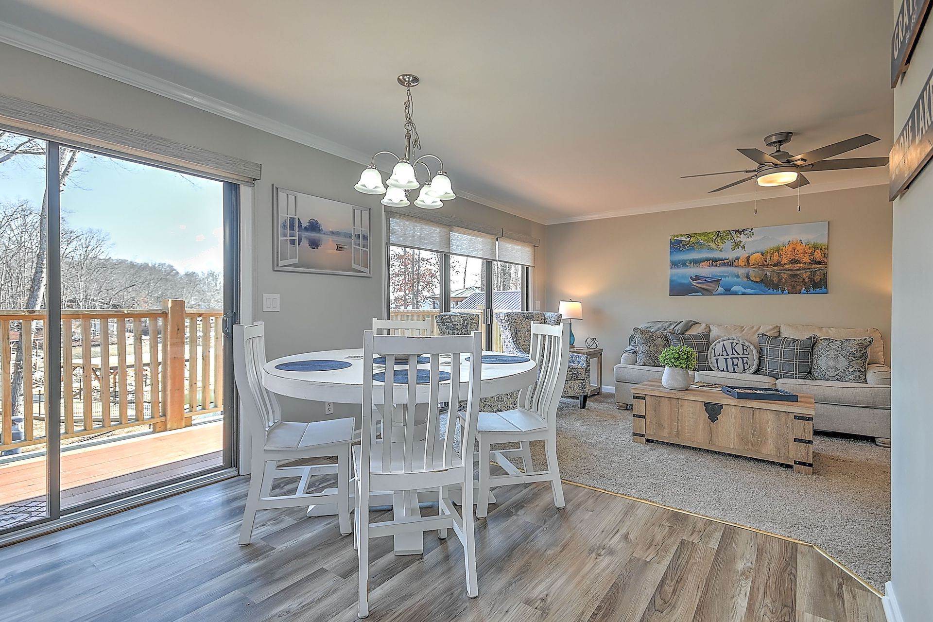 A living room with a dining table and chairs and a ceiling fan.