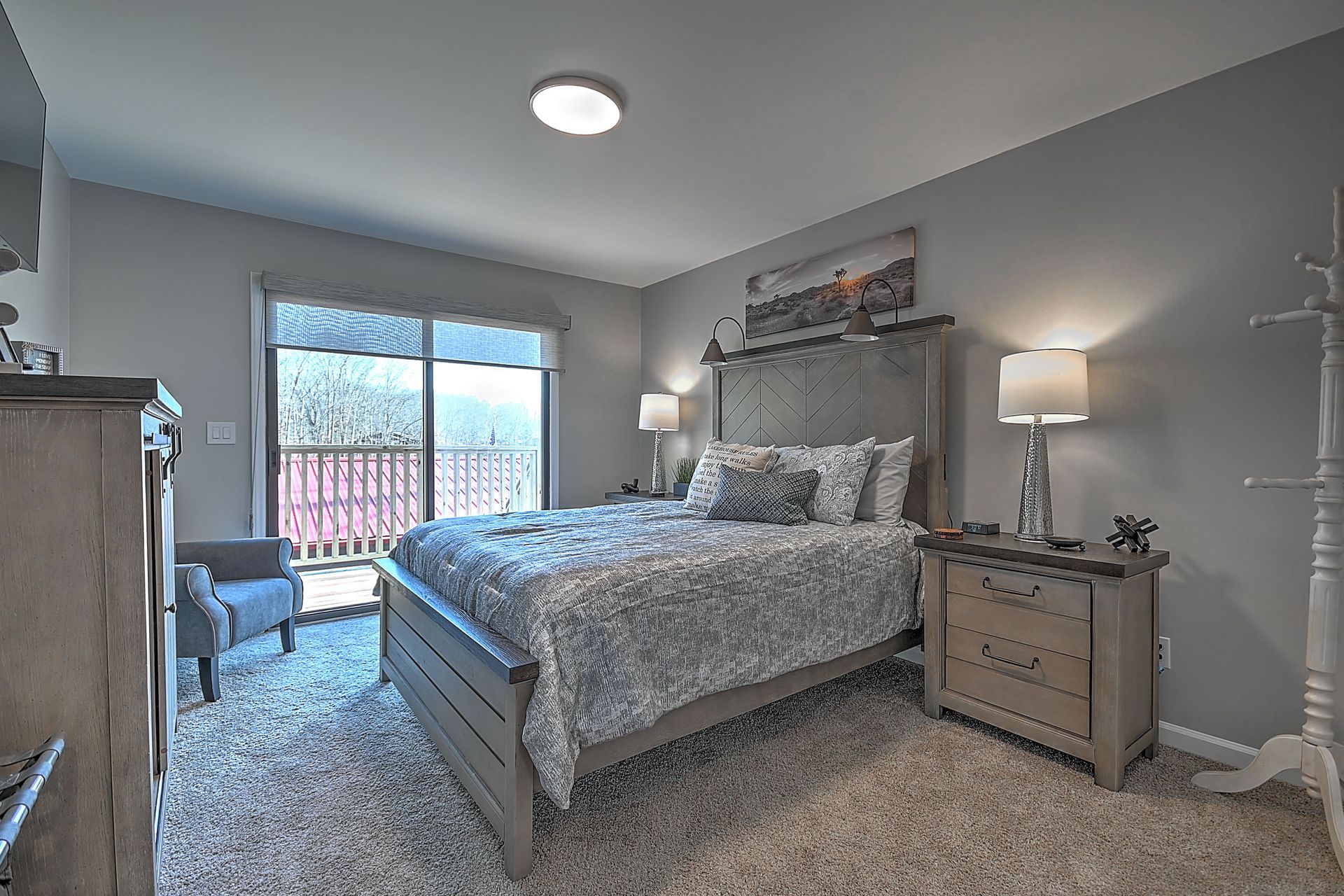 A bedroom with a king size bed , nightstand , dresser and chair.