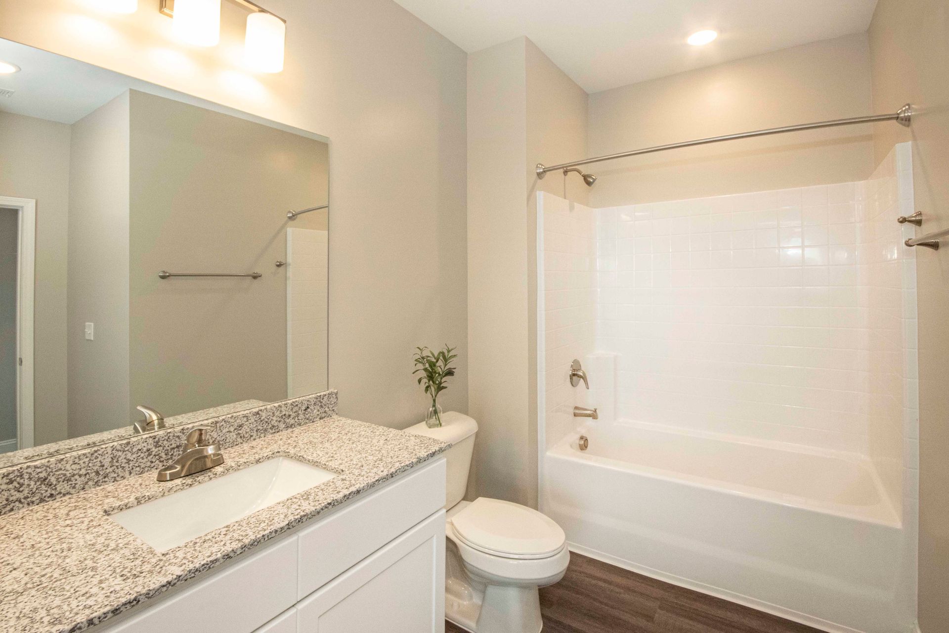 A bathroom with a sink , toilet , bathtub and mirror.
