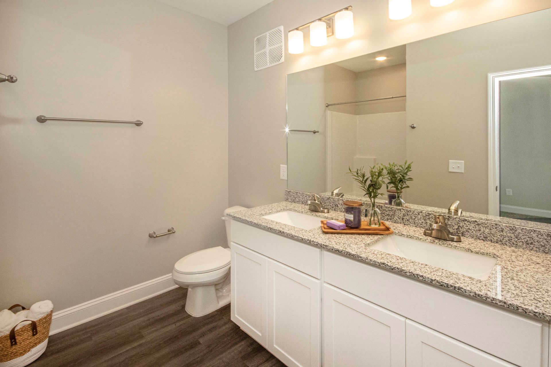 A bathroom with two sinks , a toilet , and a large mirror.