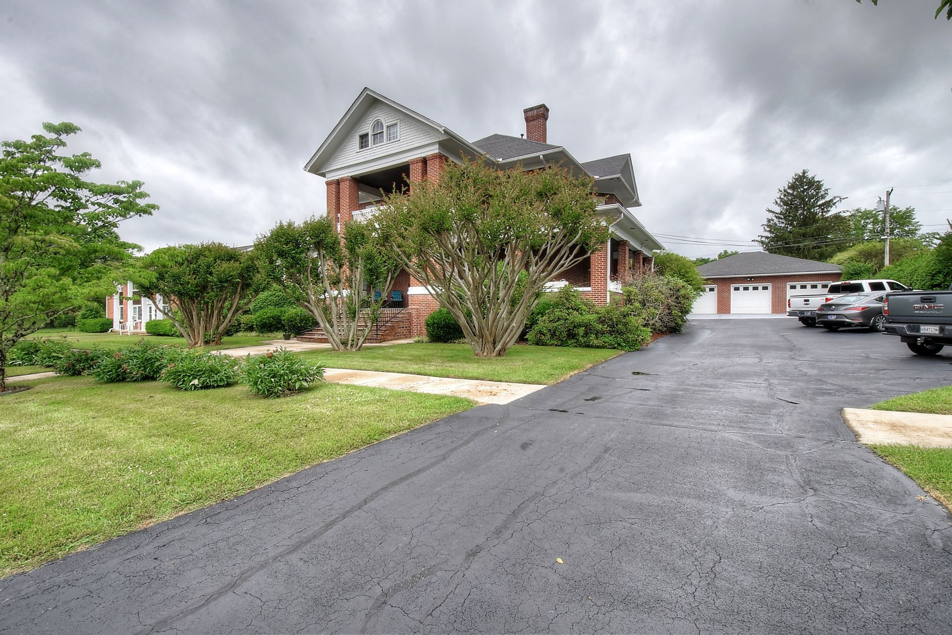 A large brick house with a driveway leading to it
