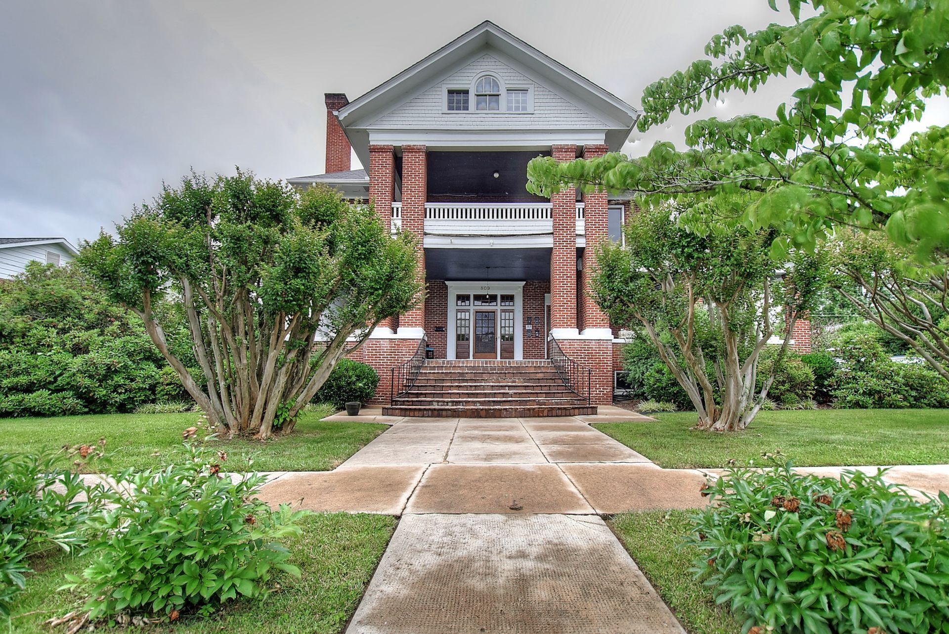 A large brick house with a walkway leading to it