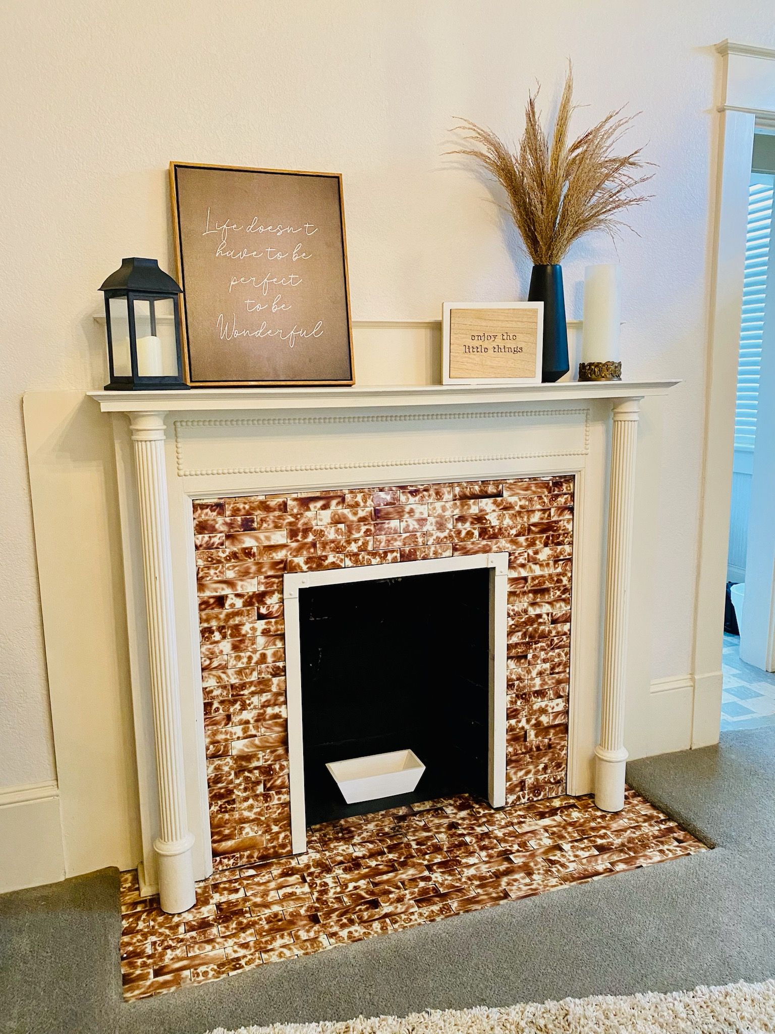 A fireplace in a living room with a sign on top of it.