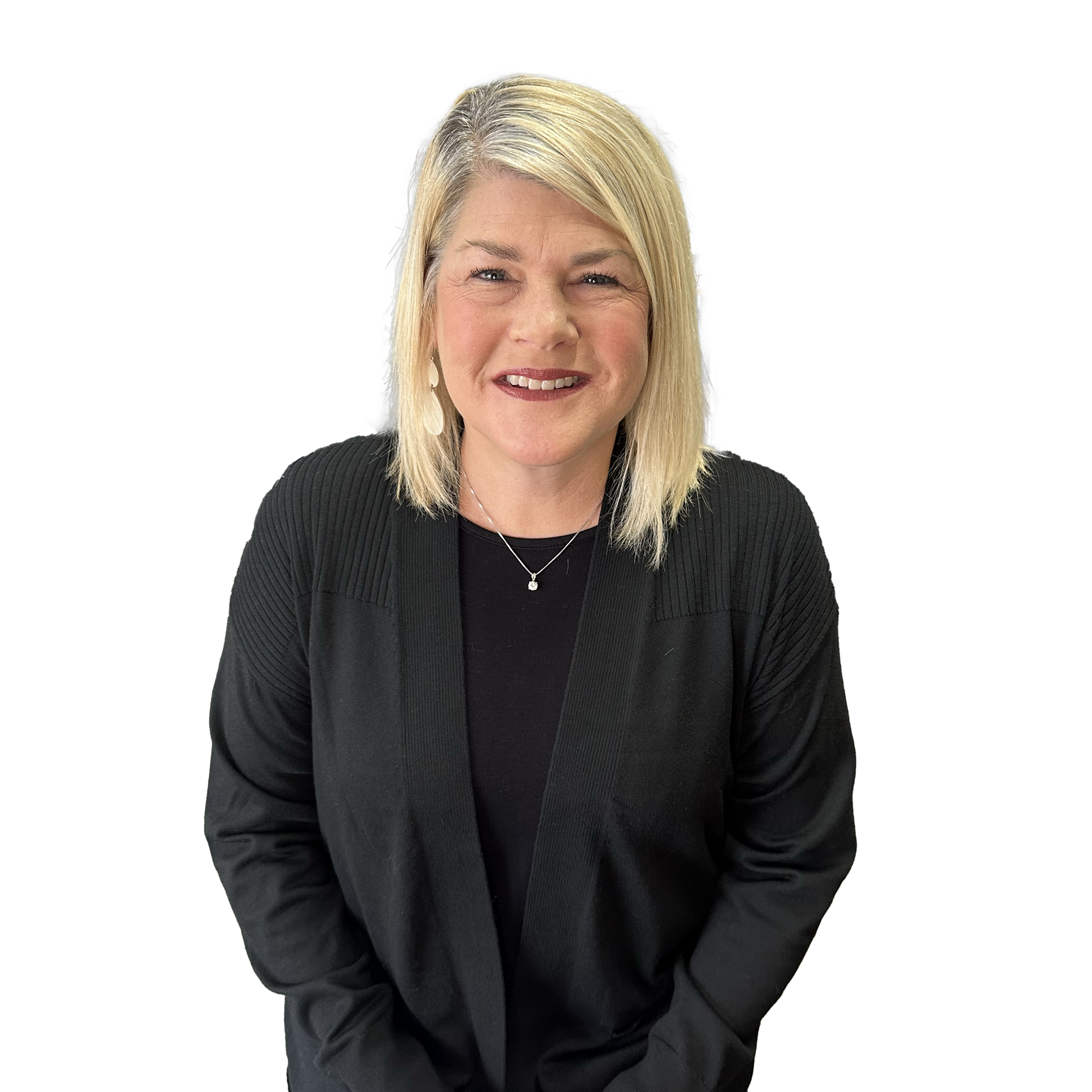 A woman wearing a black cardigan and a necklace is smiling for the camera.